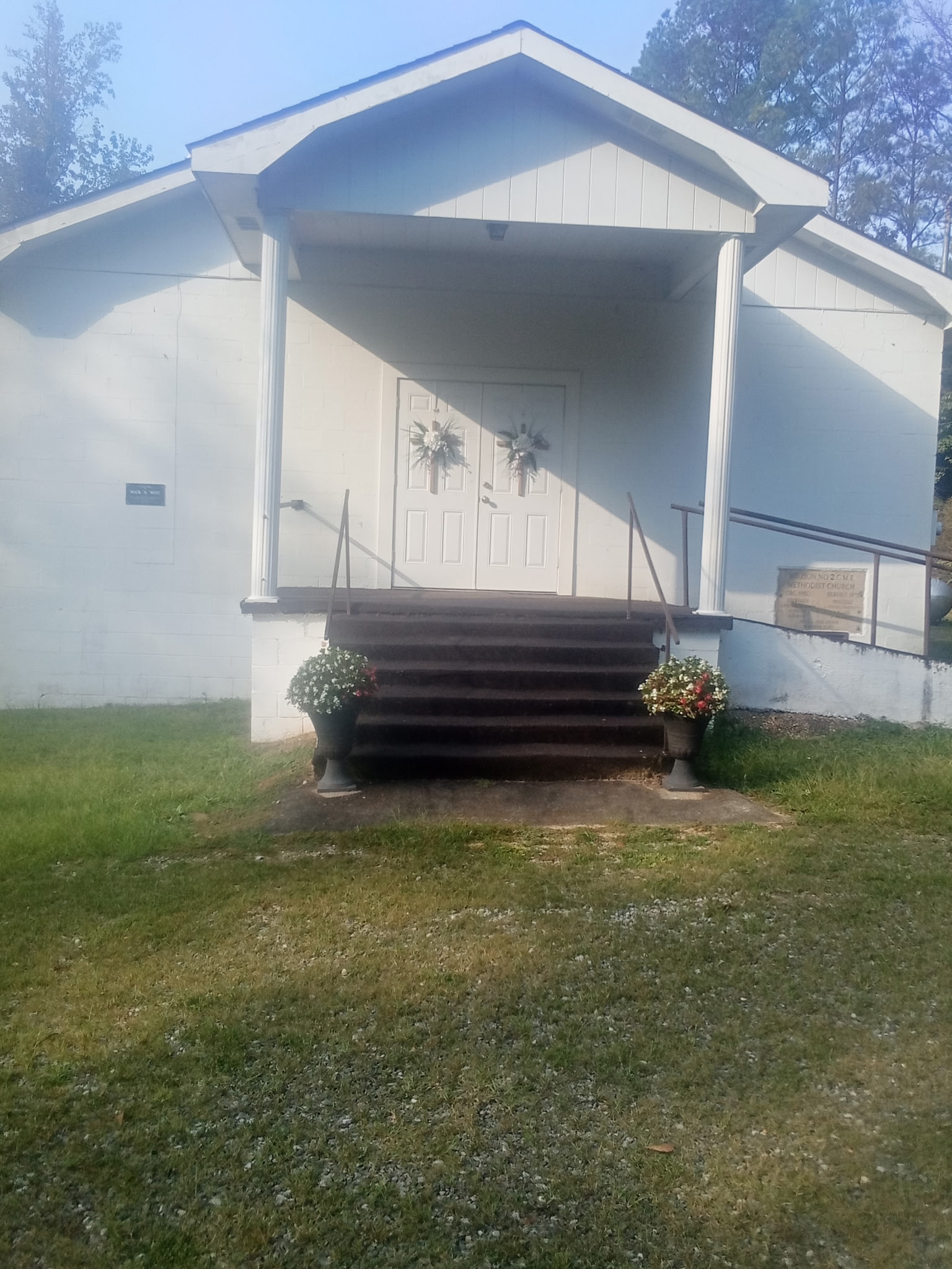 Church front with detached steeple.